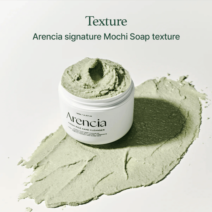 Arencia Fresh Rice Cake Cleanser i öppen burk med krämig grön mochi-liknande textur utbredd runt burken på ett vitt underlag.