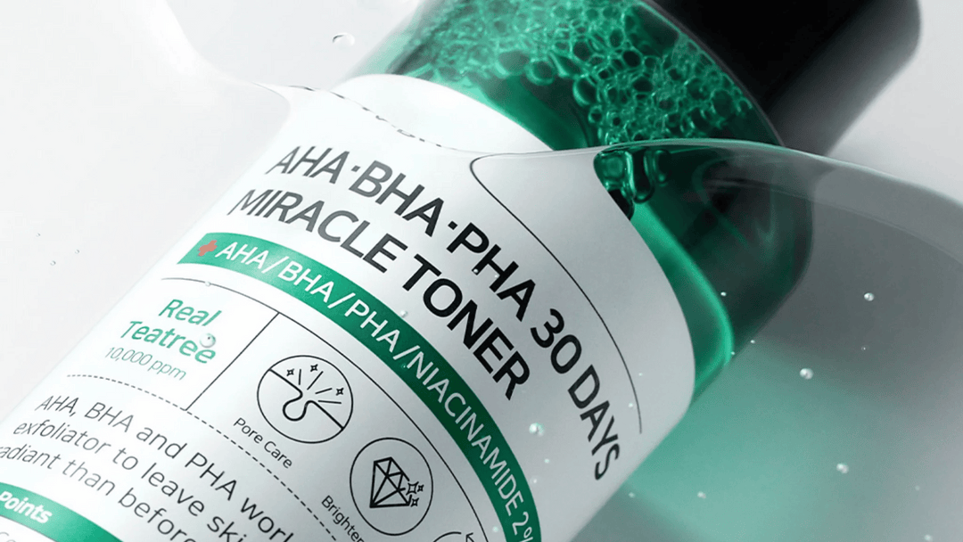 Närbild av en grön exfolierande tonerflaska med AHA, BHA och PHA för klarare hud, med detaljer och bubblor i vätskan.