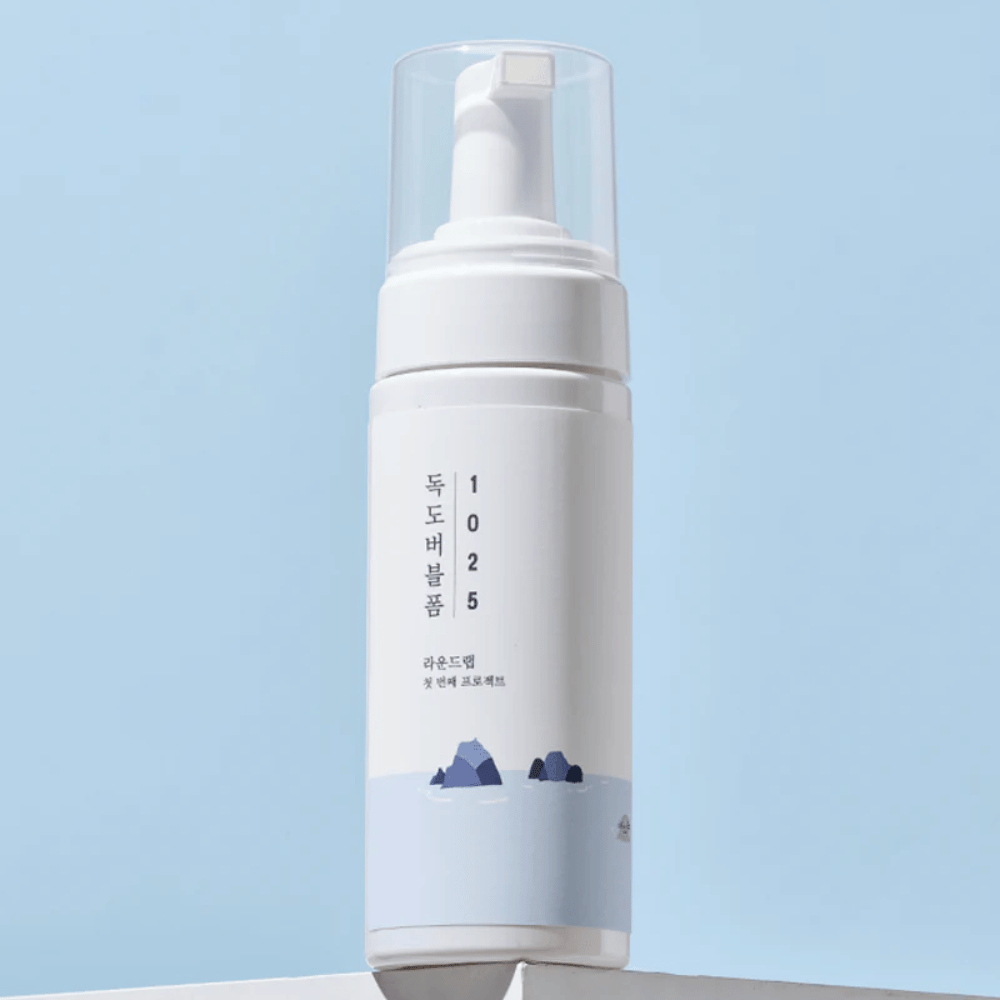  Produktet er en "1025 Dokdo Bubble Foam" fra ROUND LAB, pakket i en hvid pumpeflaske med minimalistisk design. Den er beregnet til dybderensning af ansigtet uden irritation.