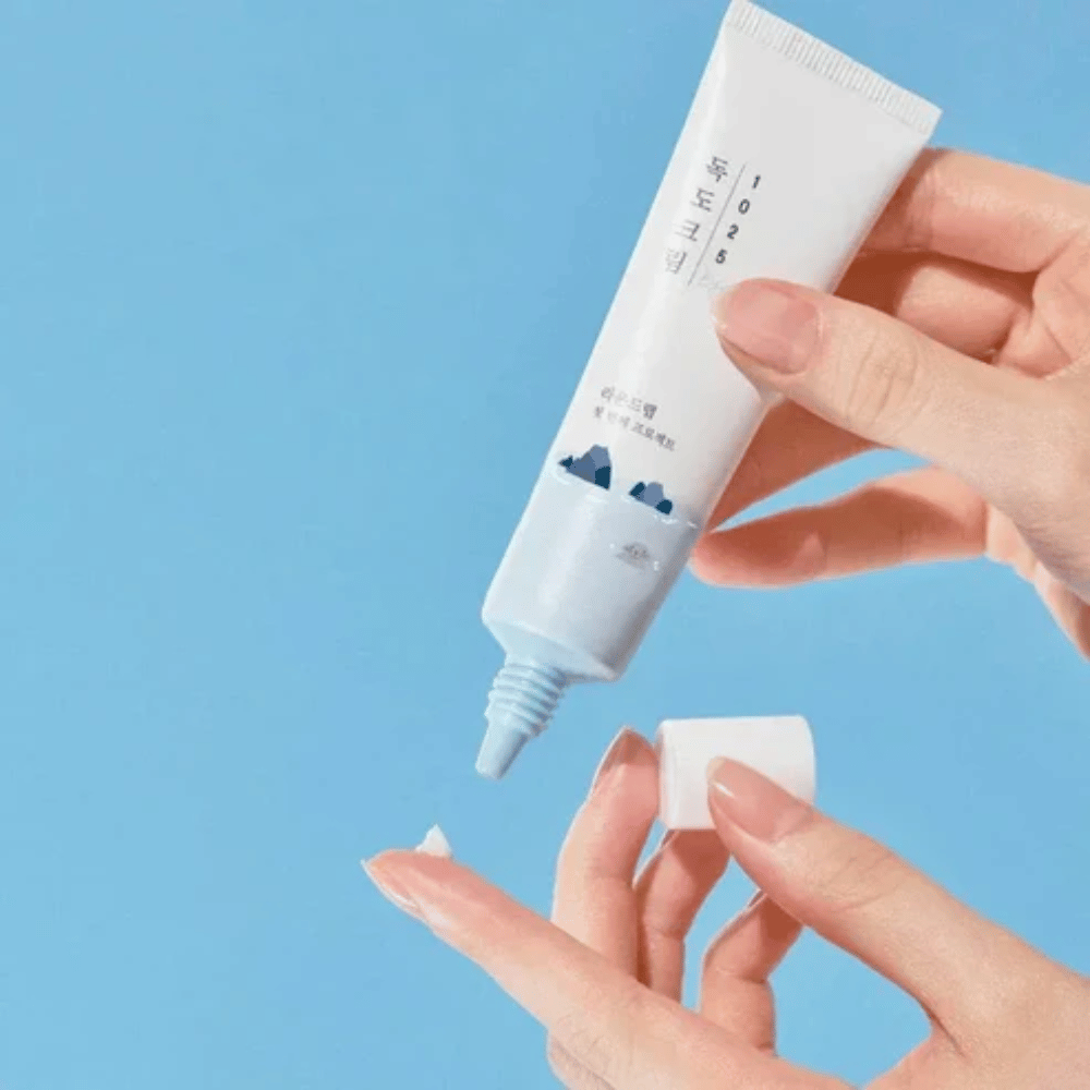 Round Lab 1025 Dokdo Eye Cream tube med let creme, som påføres på fingerspidsen for skånsom pleje af sensitiv hud omkring øjnene