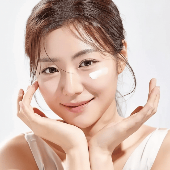 Kvinde påfører Round Lab 1025 Dokdo Eye Cream under øjnene for fugt, glød og en mere ensartet hudtone