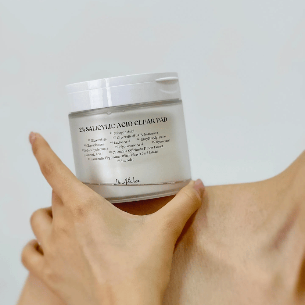 Dr. Althea 2% Salicylic Acid Clear Pad holdes i hånden. Toner pads med 2% salicylsyre, der eksfolierer skånsomt, beroliger huden og forbedrer hudstrukturen.