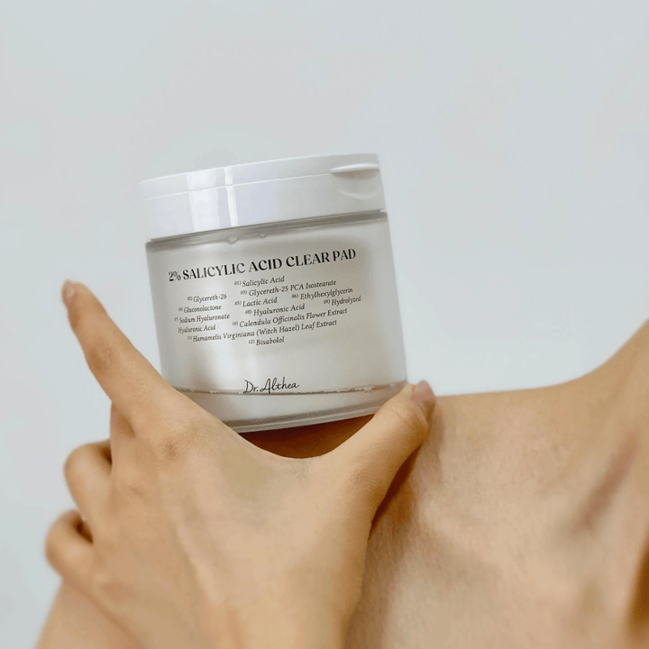 Dr. Althea 2% Salicylic Acid Clear Pad holdes i hånden. Toner pads med 2% salicylsyre, der eksfolierer skånsomt, beroliger huden og forbedrer hudstrukturen.