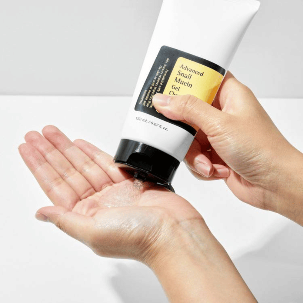 Hånd påfører COSRX Advanced Snail Mucin Gel Cleanser – skånsom gelrens med snegleslim som renser i dybden og bevarer hudens fugtbalance.