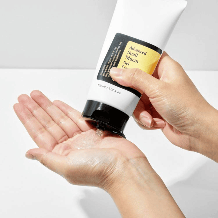 Hånd påfører COSRX Advanced Snail Mucin Gel Cleanser – skånsom gelrens med snegleslim som renser i dybden og bevarer hudens fugtbalance.