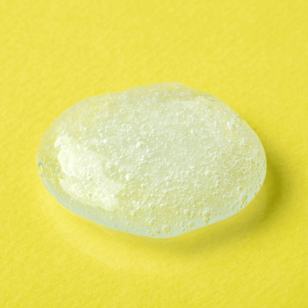 Transparent gel-tekstur fra COSRX Advanced Snail Mucin Gel Cleanser på gul baggrund – fugtgivende ansigtsrens med sneglesekret for blød og balanceret hud.