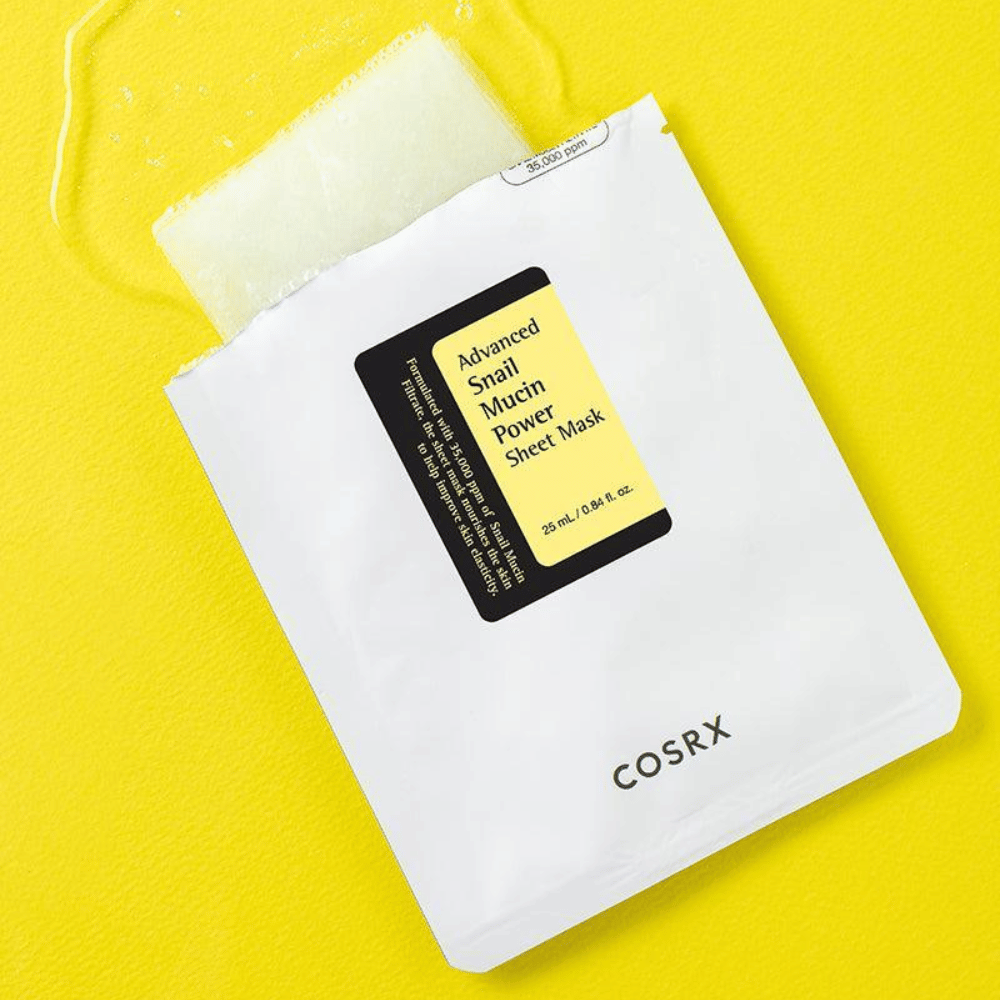 COSRX Advanced Snail Mucin Power Sheet Mask på gul baggrund, en fugtgivende og reparerende ansigtsmaske med snegleekstrakt for øget elasticitet og glans.