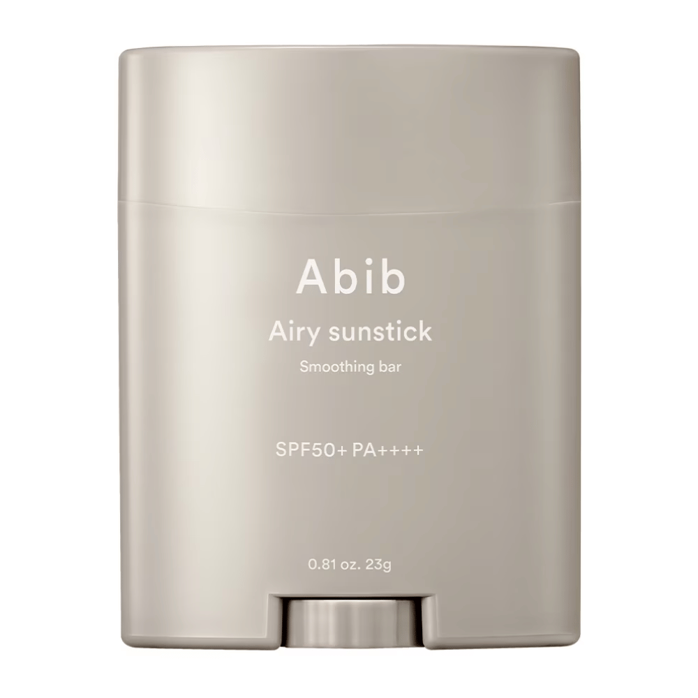 Billedet viser en beige solbeskyttelsesstick fra Abib med teksten "Airy Sunstick Smoothing Bar" og solbeskyttelsesfaktor SPF50+ PA++++, perfekt til daglig beskyttelse mod UV-stråler.
