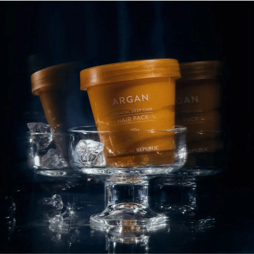 Nature Republic Argan Essential Moisture Repairing Hair Mask placeret på glasfad med isterninger – luksuriøs og plejende hårmaske.