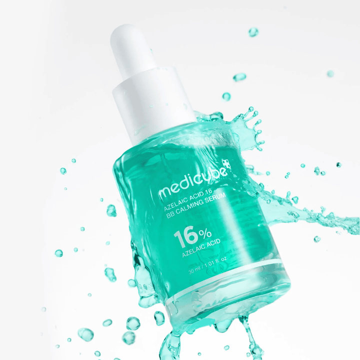 Dynamisk produktbillede af Medicube Azelaic Acid 16 BB Calming Serum omgivet af vandsprøjt, som fremhæver en frisk, let og fugtgivende følelse.