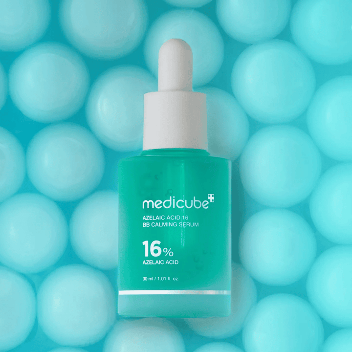 Kampagnebillede af Medicube Azelaic Acid 16 BB Calming Serum mod turkis baggrund med bløde sfærer, som symboliserer fugt, beroligende effekt og ensartet hudstruktur.