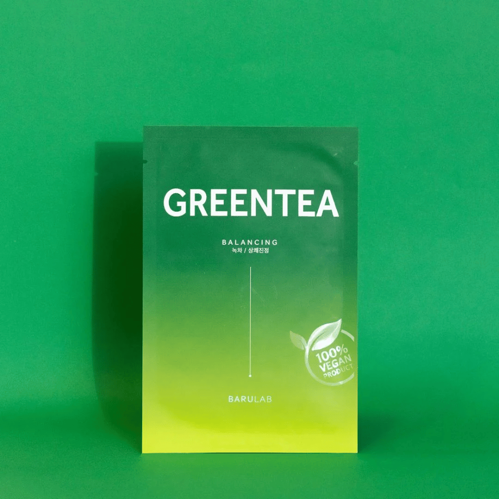 En pakke fra BARULAB til en "GREENTEA Balancing" maske, markeret som "100% Vegan Product". Pakkens farve går fra mørkegrøn foroven til lysere grøn forneden, mod en ensartet grøn baggrund.