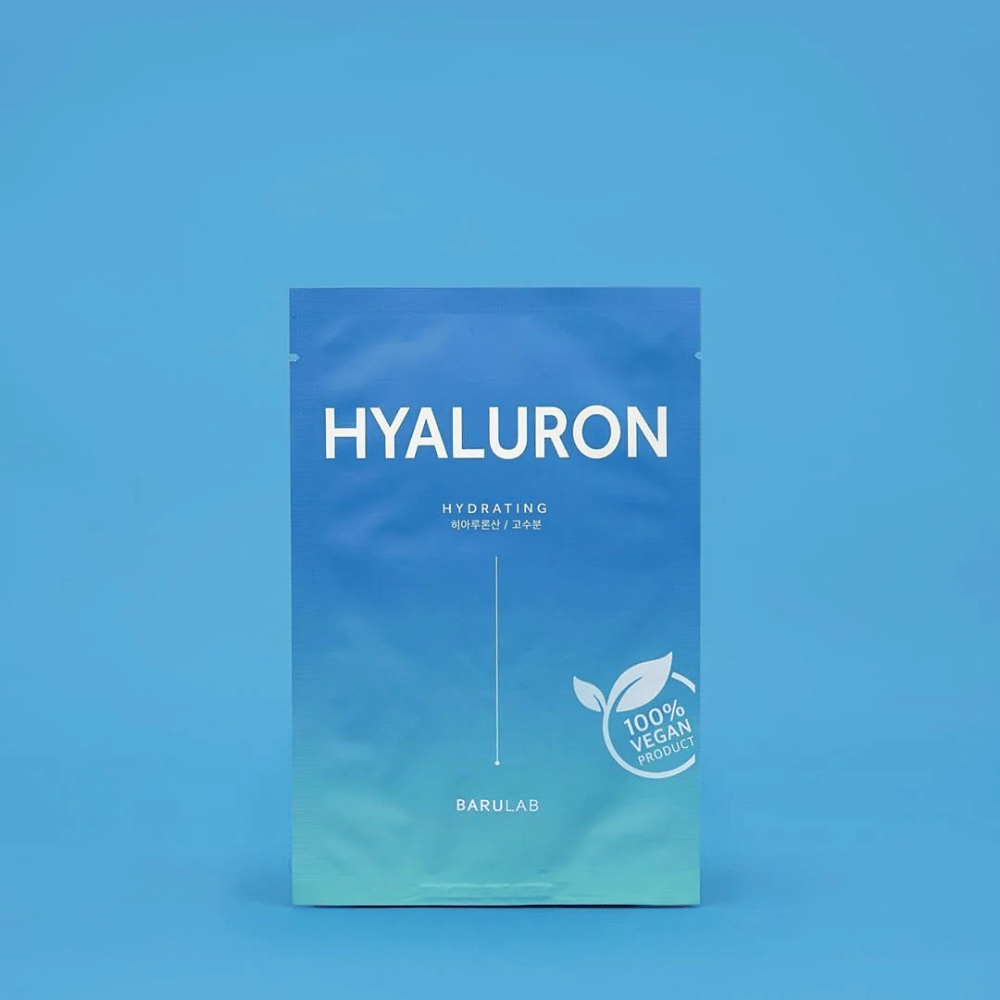 En pakke med BARULAB "HYALURON Hydrating" maske, mærket som "100% Vegan Product", foran en ensartet blå baggrund. Pakken har en farvegradient fra mørkeblå til lyseblå.