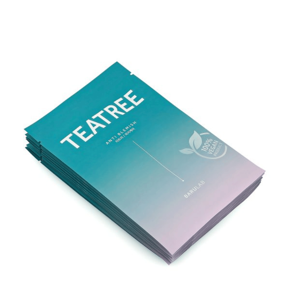 En bunke af pakker med BARULAB "TEATREE Anti Blemish" masker, alle mærket som "100% Vegan Product". Pakkerne har en ensartet turkis farve.