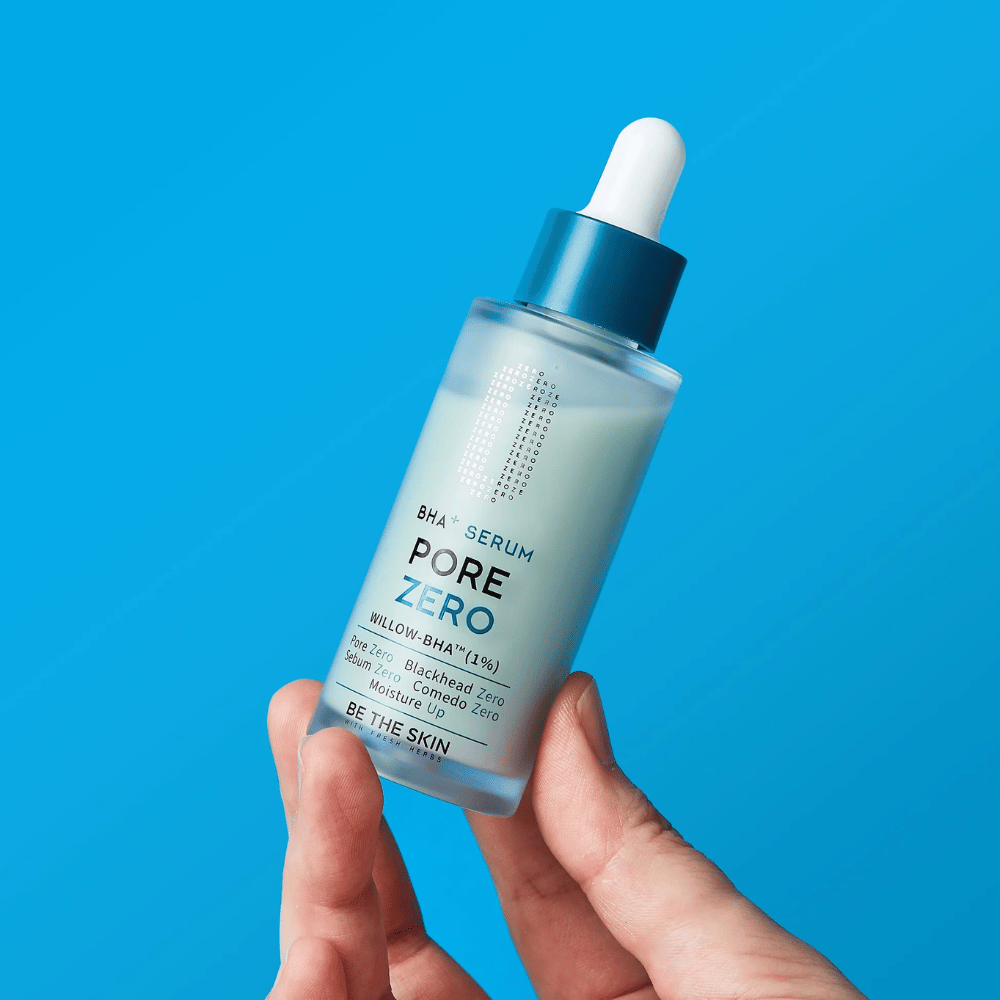Be The Skin BHA+ Pore Zero Serum holdes i hånden mod blå baggrund