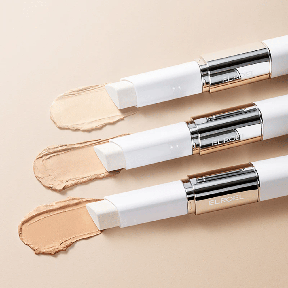 ELROEL Blanc Cover Cream Stick concealer med indbygget børste, flere sticks opstillet, der viser produktets design og påføring.