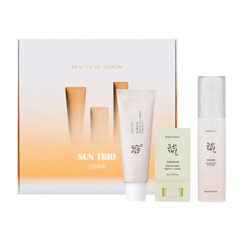 Beauty of Joseon - Sun Trio gaveæske med tre solbeskyttelsesprodukter: Relief Sun Rice + Probiotics, Matte Sun Stick Mugwort + Camellia og Ginseng Moist Sun Serum foran en gradientpakning i hvidt og orange.