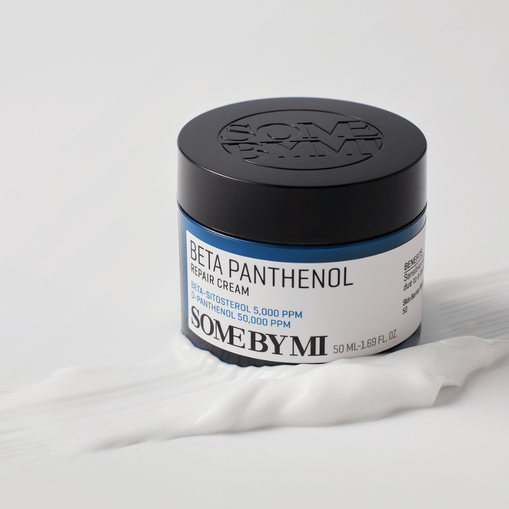 SOME BY MI Beta Panthenol Repair Cream i blå krukke placeret på creme tekstur – beroligende og fugtgivende hudcreme.
