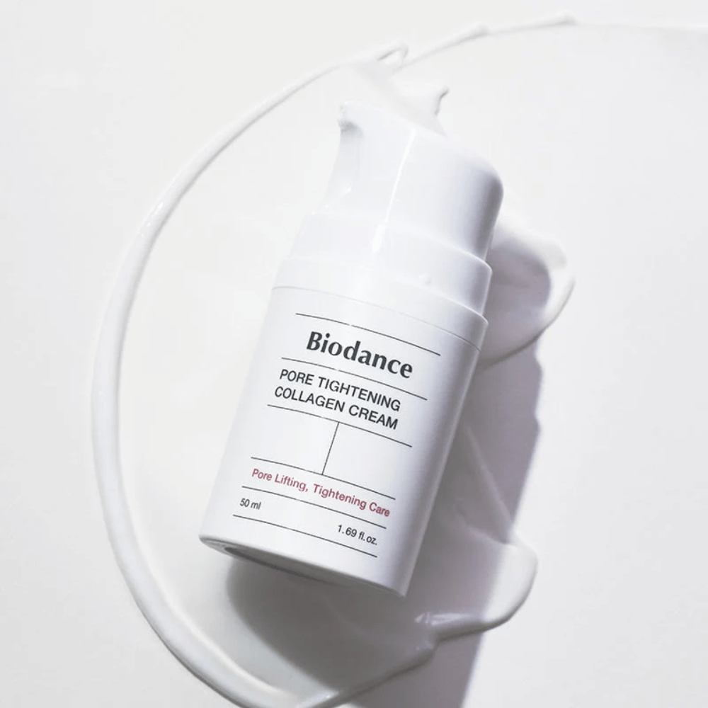 Biodance Pore Tightening Collagen Cream i hvid pumpeflaske, liggende på en swirl af hvid creme.