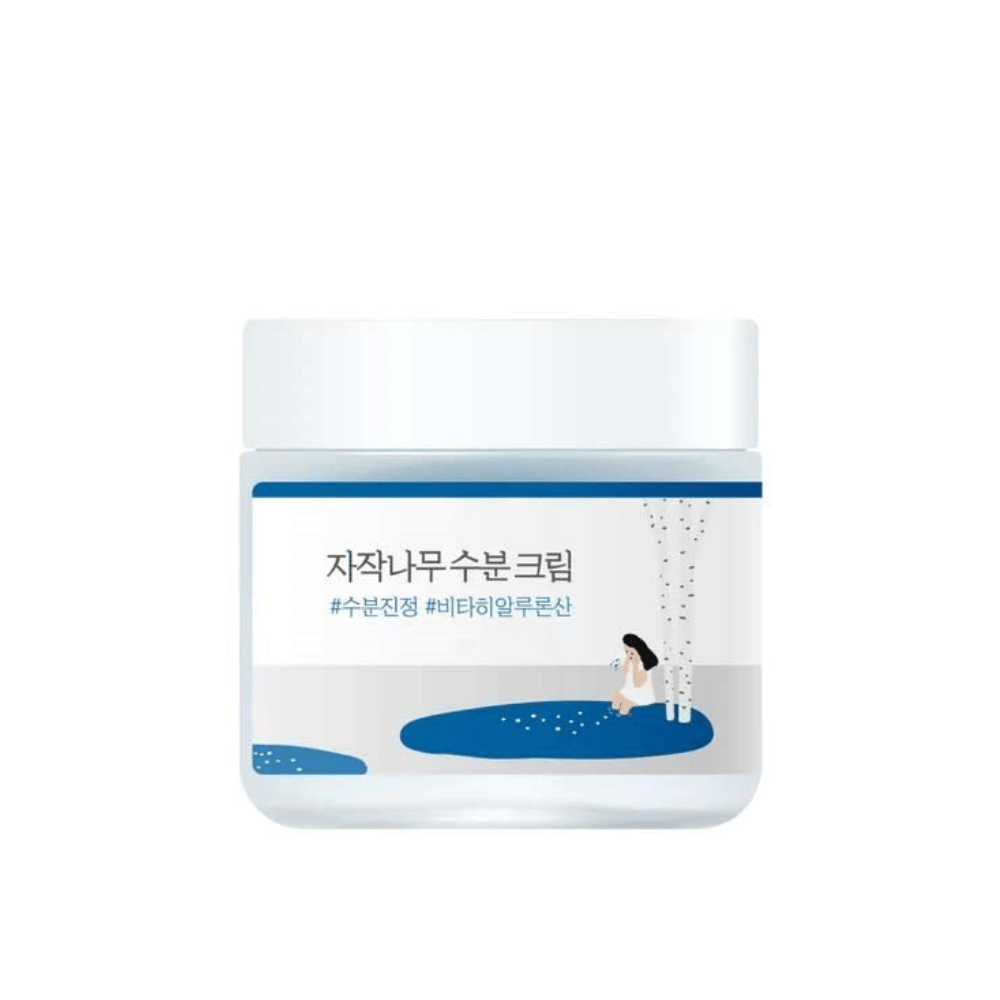 Round Lab Birch Juice Moisturizing Cream i gennemsigtig krukke med hvidt låg og blå etiket med illustration af birk og pige, frilagt mod hvid baggrund.