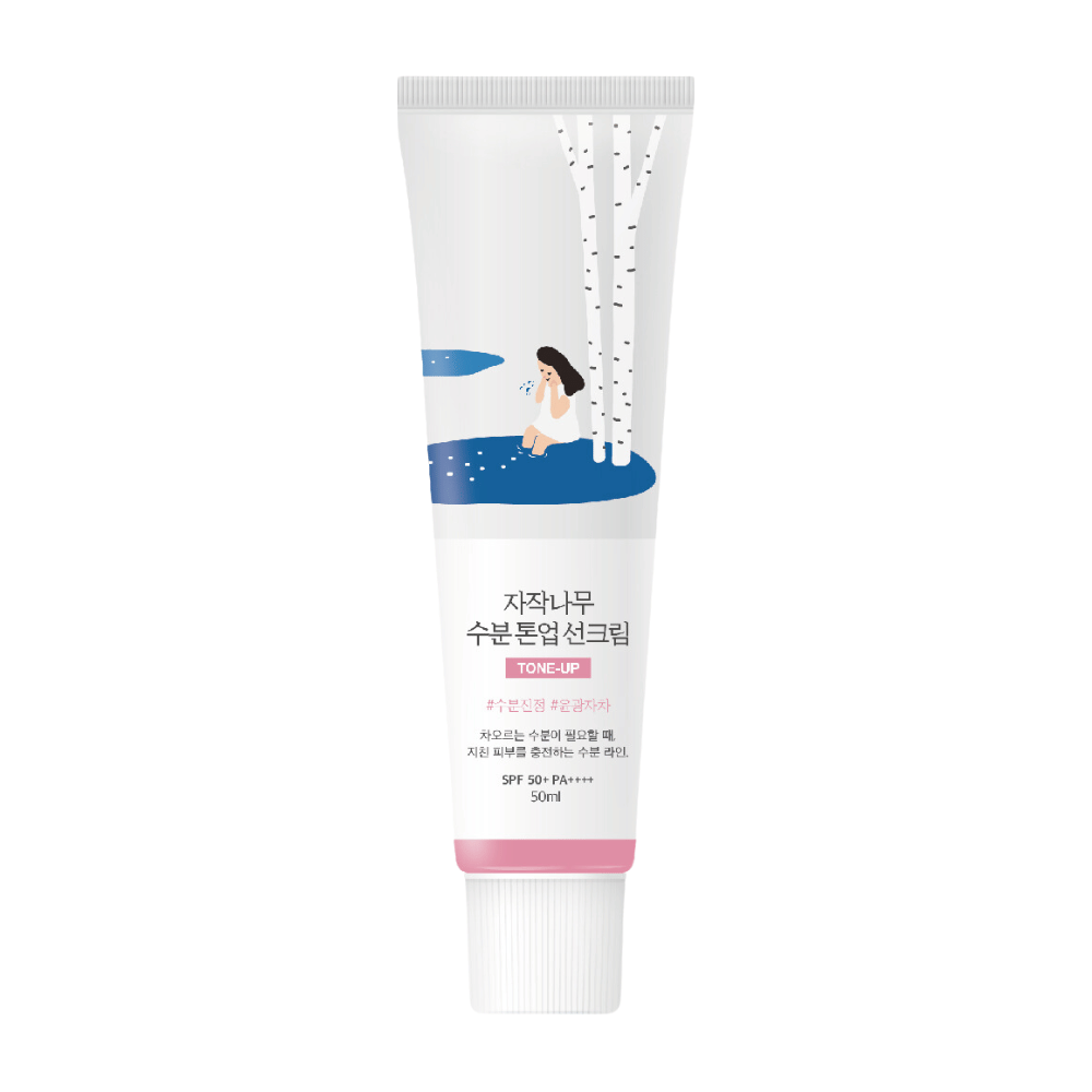 En hvid tube med Birch Juice Moisturizing Tone Up Sunscreen. Tuben har en illustration af en kvinde, der sidder ved en birk ved siden af en vandpyt. Teksten på tuben er på koreansk og angiver, at produktet har SPF 50+ PA++++ og indeholder 50 ml.