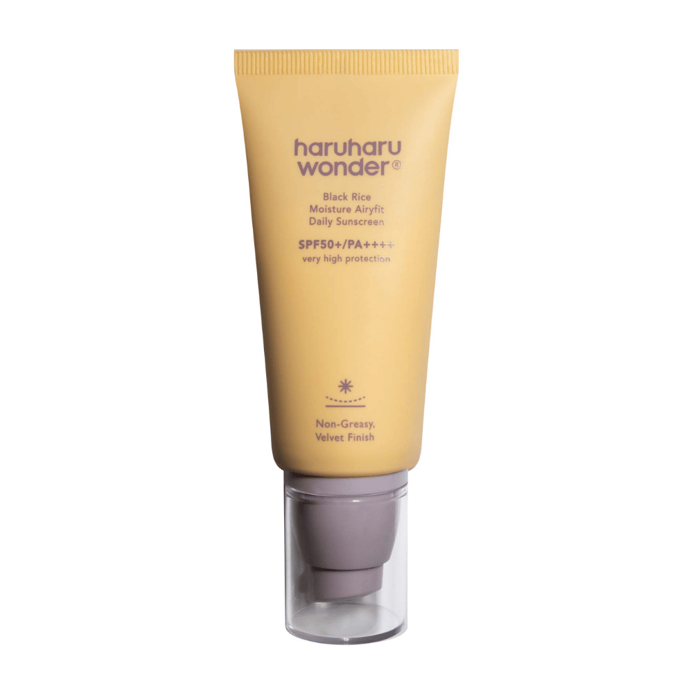En gul tube med Haruharu Wonder Black Rice Moisture Airyfit Daily Sunscreen SPF 50+ PA++++. Tuben har en gennemsigtig hætte og tekst, der beskriver solcremens høje beskyttelsesniveau samt dens ikke-fedtede, fløjlsbløde finish.