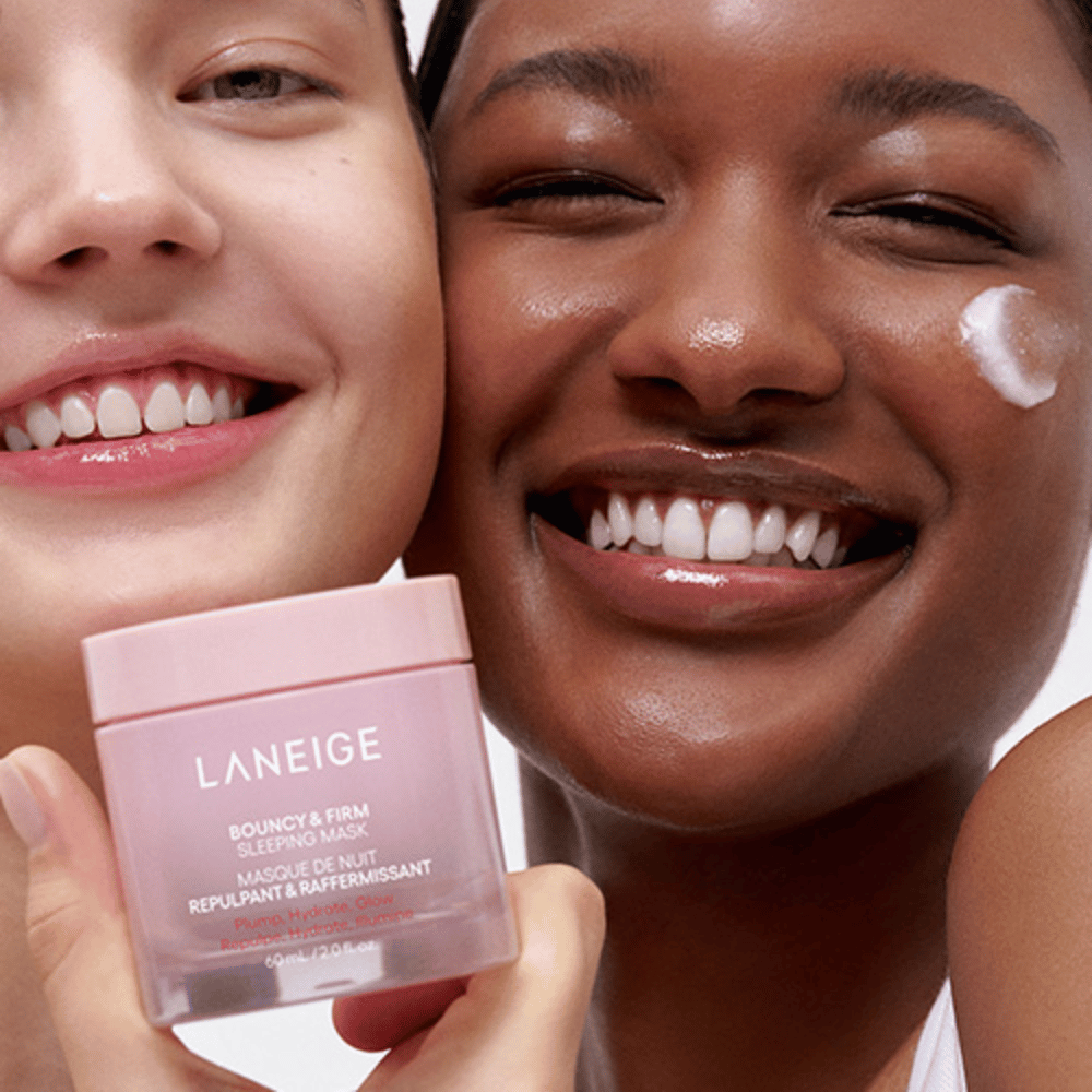 To personer smiler og holder Laneige Bouncy & Firm Sleeping Mask. Den ene har påført masken på sin kind, og produktet ses tydeligt i deres hænder. Masken er i en rosa krukke og markedsføres som "Plump, Hydrate, Glow."]