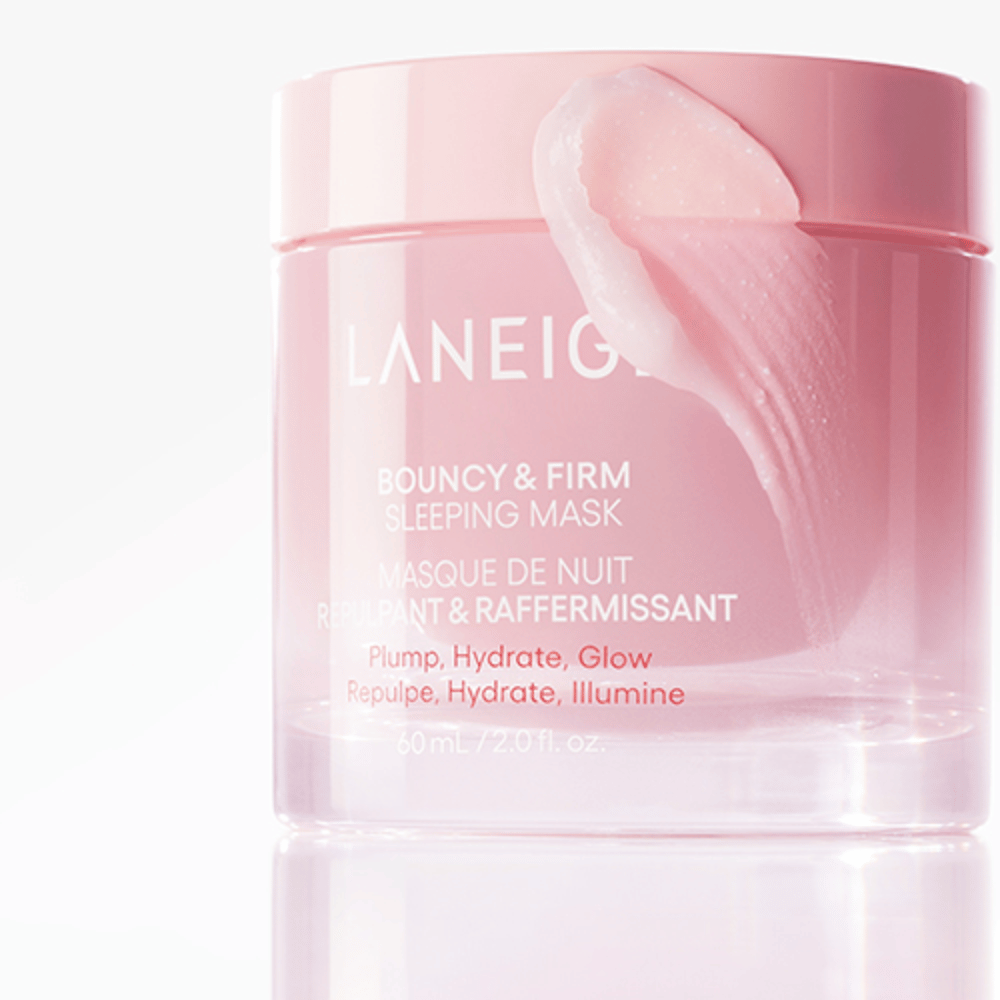 Nærbillede af Laneige Bouncy & Firm Sleeping Mask i en rosa krukke, med en del af masken påført kanten af låget. Produktet er beregnet til at give fylde, fugt og glød. Krukken rummer 60 ml og har teksten "Plump, Hydrate, Glow."