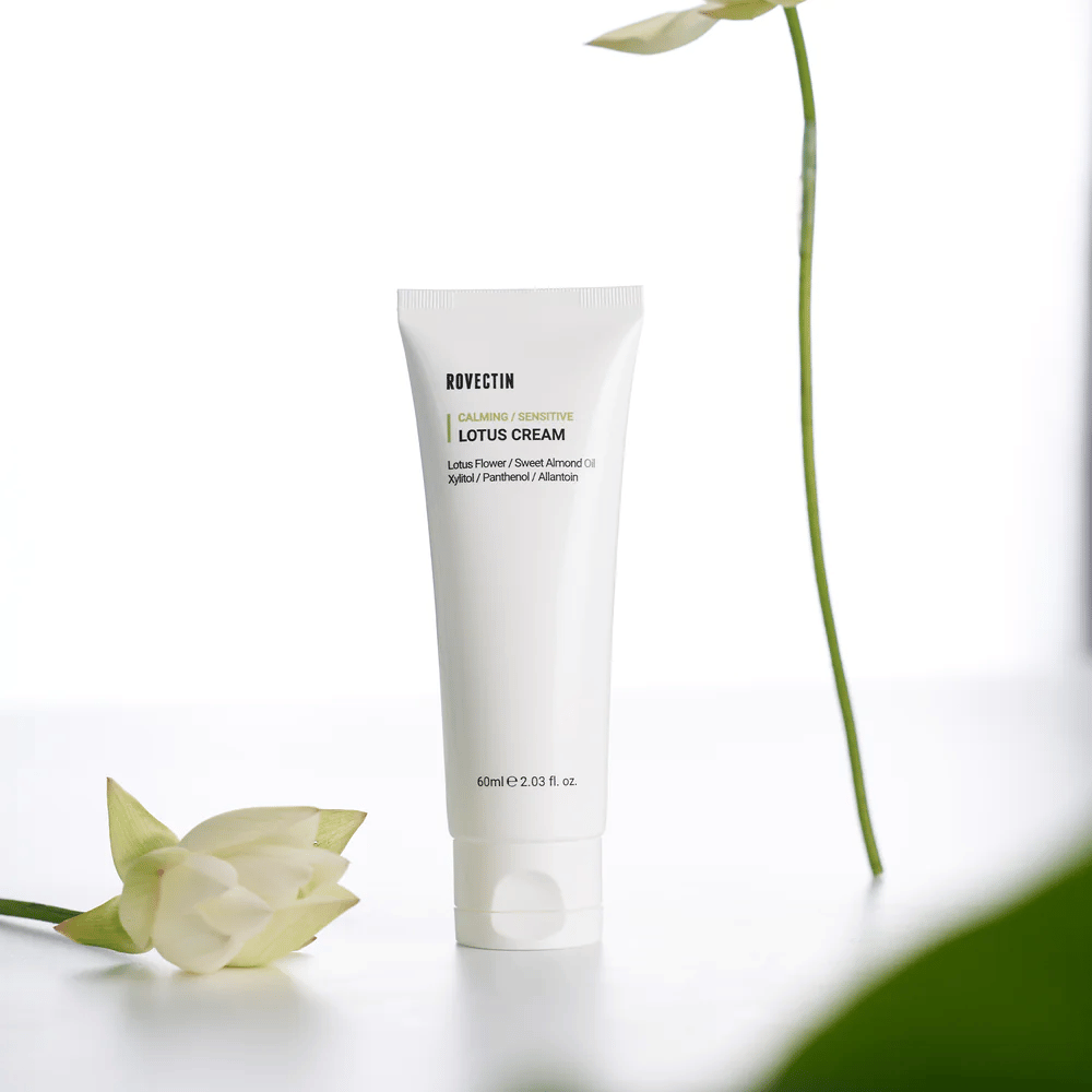 Tube med Rovectin Lotus Cream til beroligende og følsom hudpleje, præsenteret med en lotusblomst.