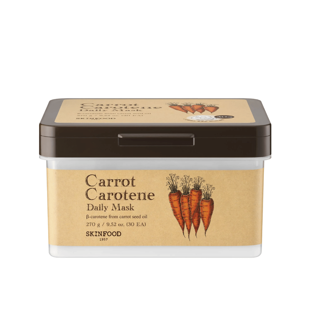 En pakke "Carrot Carotene Daily Mask" fra SKINFOOD, indeholdende 30 ansigtsmasker. Produktet er beriget med β-caroten fra gulerodsfrøolie og er designet til daglig brug. Pakken er robust med en vintage-inspireret etiket, der fremhæver gulerødderne som hovedingrediens.