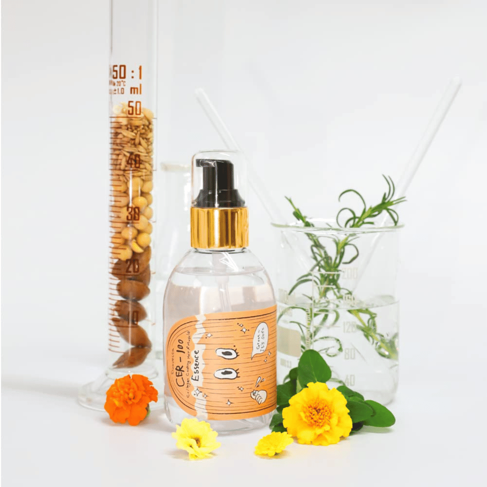 CER-100 Hair Essence sammen med blomster og laboratorieglas, der fremhæver ingredienser og hårpleje.