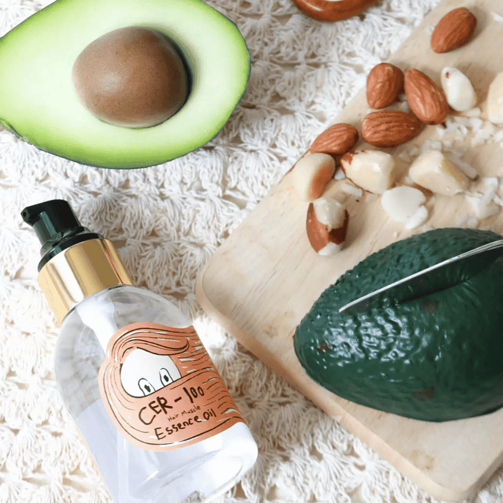 Elizavecca CER-100 Hair Muscle Essence Oil ingredienser – nærbillede med avocado og planteolier, der viser en næringsrig hårolie, som hjælper med at blødgøre og pleje håret.