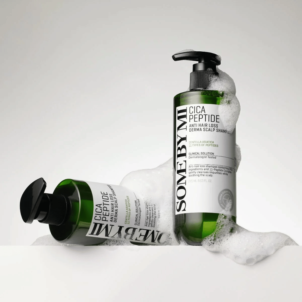 To flasker af SOME BY MI Cica Peptide Anti Hair Loss Derma Scalp Shampoo dækket af skum, stående og liggende mod hvid baggrund.
