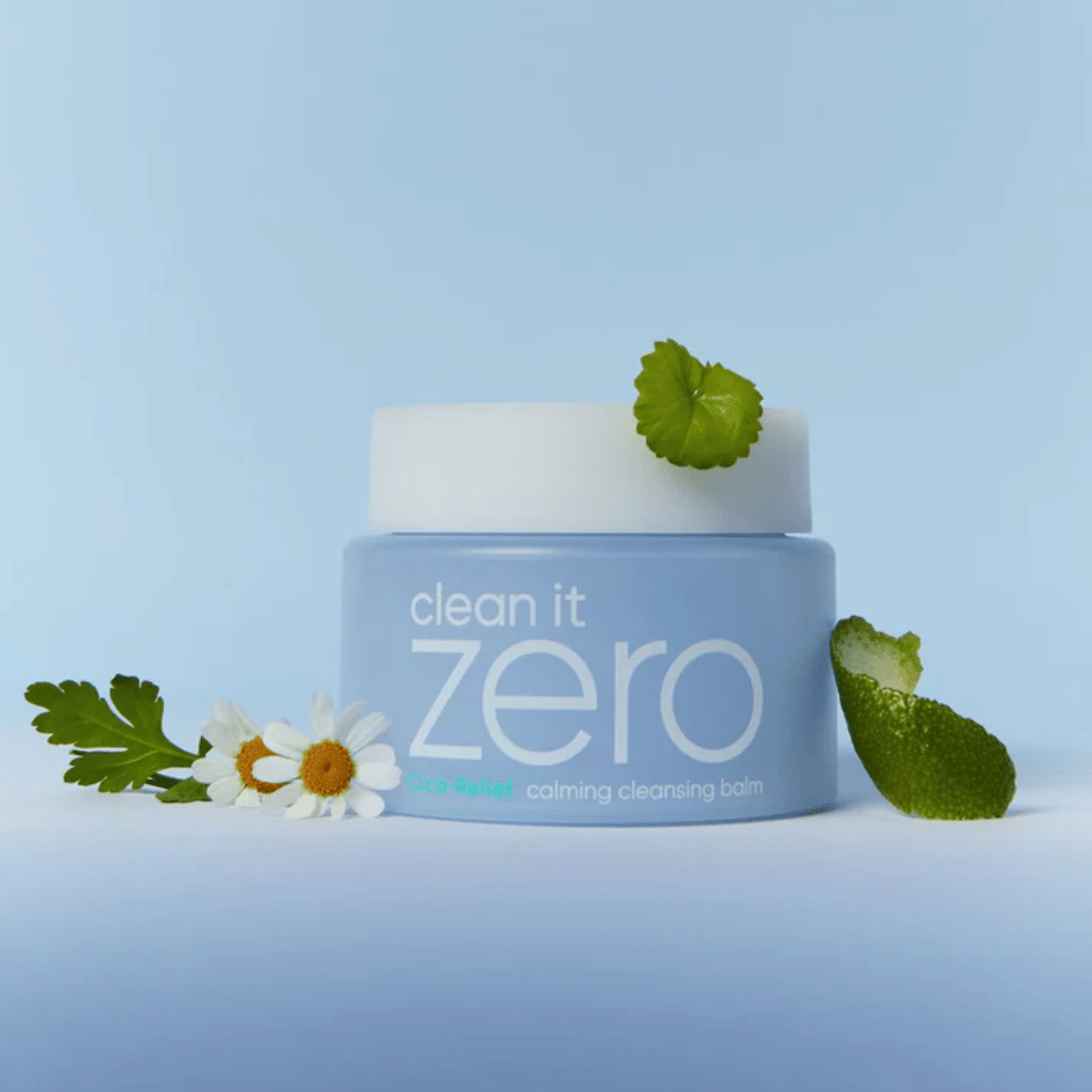 Clean It Zero Cica-Relief Calming Cleansing Balm placeret med planter og blomster, illustrerer mild rensning med beroligende CICA til følsom og irriteret hud.