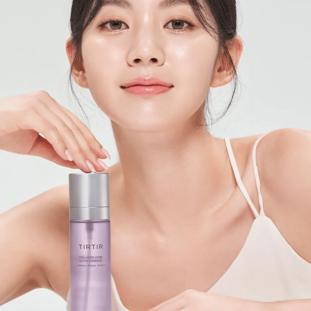 Kvinde med strålende hud poserer med TIRTIR Collagen Core Glow Essence – en glansgivende essence for fastere og fugtet hud.
