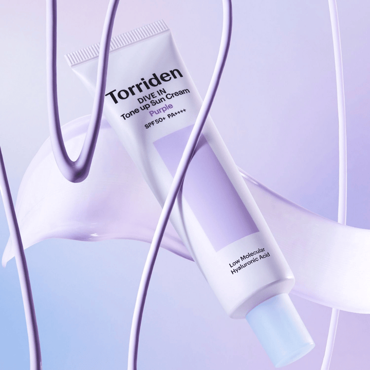 Torriden DIVE IN Tone Up Sun Cream Purple SPF50+ PA++++ præsenteret i et kreativt produktmiljø med lilla detaljer, der fremhæver den fugtgivende formel.