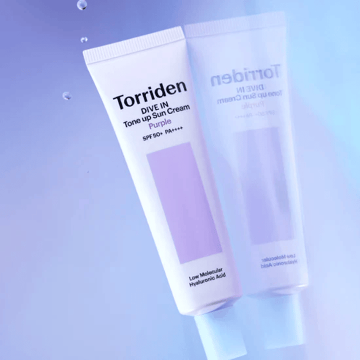 Torriden DIVE IN Tone Up Sun Cream Purple SPF50+ PA++++ fotograferet mod en blød lilla baggrund, som fremhæver produktets lysreflekterende design.