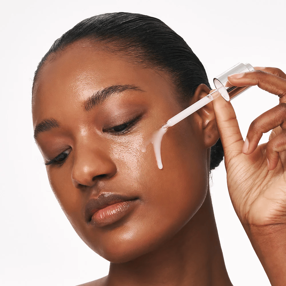 Person anvender Deep Collagen Power Boosting Cream in Serum på kinden med pipette. Serummet giver fastere, fugtet hud med glød.