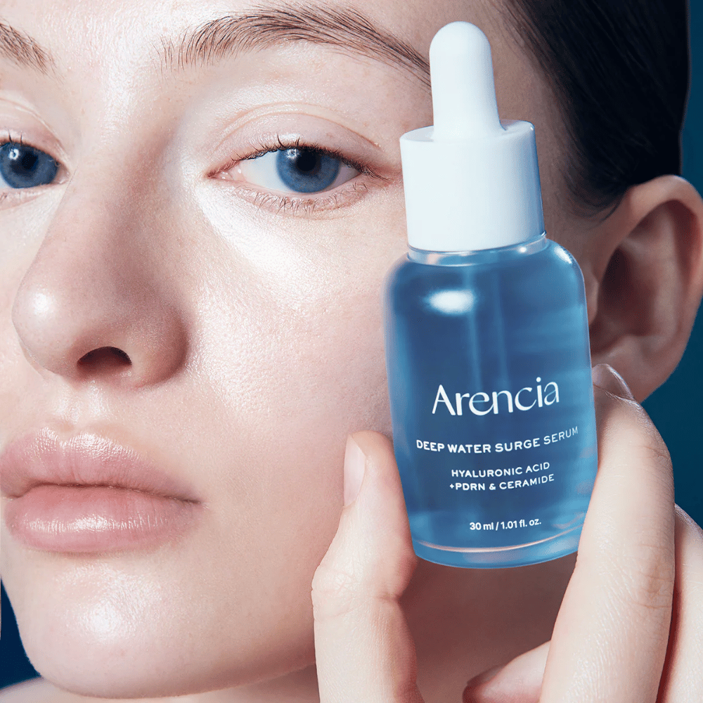 Model anvender Arencia Deep Water Surge Serum – fugtgivende koreansk serum med hyaluronsyre, PDRN og ceramider, der beroliger følsom hud og styrker hudbarrieren.