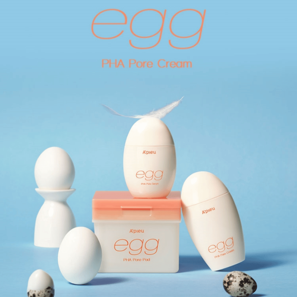 A'pieu Egg PHA Pore-serie – æggeformede produkter som serum, creme og pads, stilfuldt arrangeret på blå baggrund med æg og fjer, der symboliserer skånsom hudpleje.