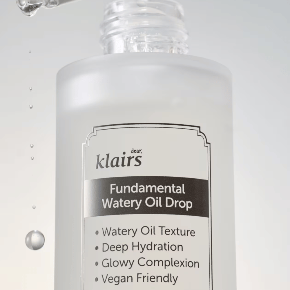 Nærbillede af flasken Klairs Fundamental Watery Oil Drop, med tekst der fremhæver produktets egenskaber som "Watery Oil Texture", "Deep Hydration", "Glowy Complexion" og "Vegan Friendly".