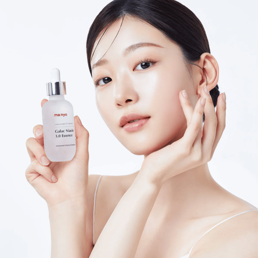 Kvinde med strålende hud holder Ma:nyo Galac Niacin 3.0 Essence – koreansk essence, der giver en mere jævn hudtone og naturlig glød.
