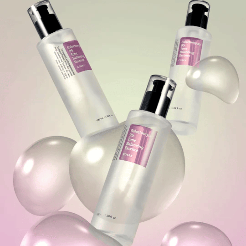 Tre flasker af COSRX Galactomyces 95 Tone Balancing Essence omgivet af lyse bobler. Hudforbedrende essens som jævner hudtonen og giver naturlig glans.