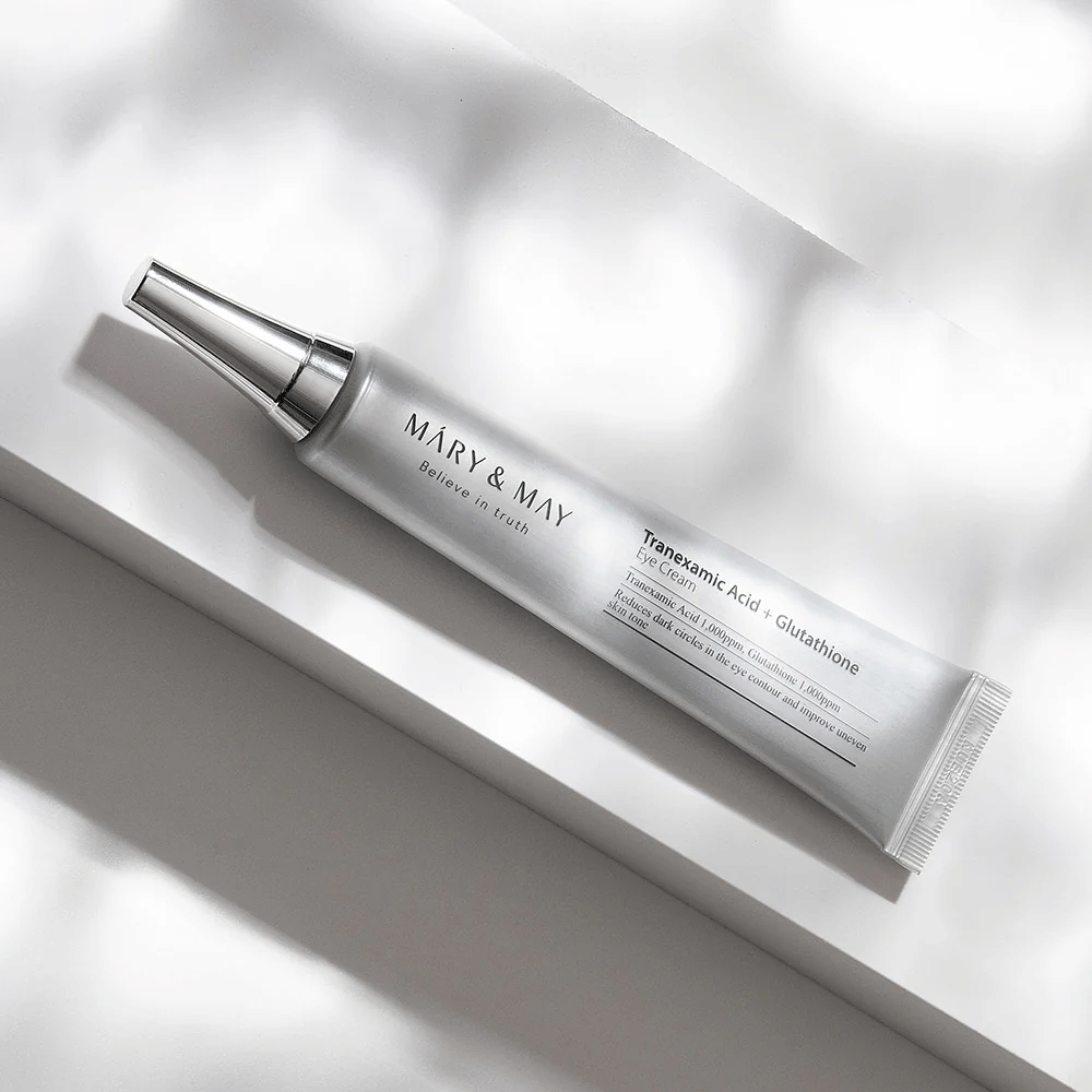 Nærbillede af Mary&May Tranexamic Acid + Glutathione Eye Cream med metalapplikator, udviklet til at lysne mørke rande og udjævne hudtonen omkring øjnene.