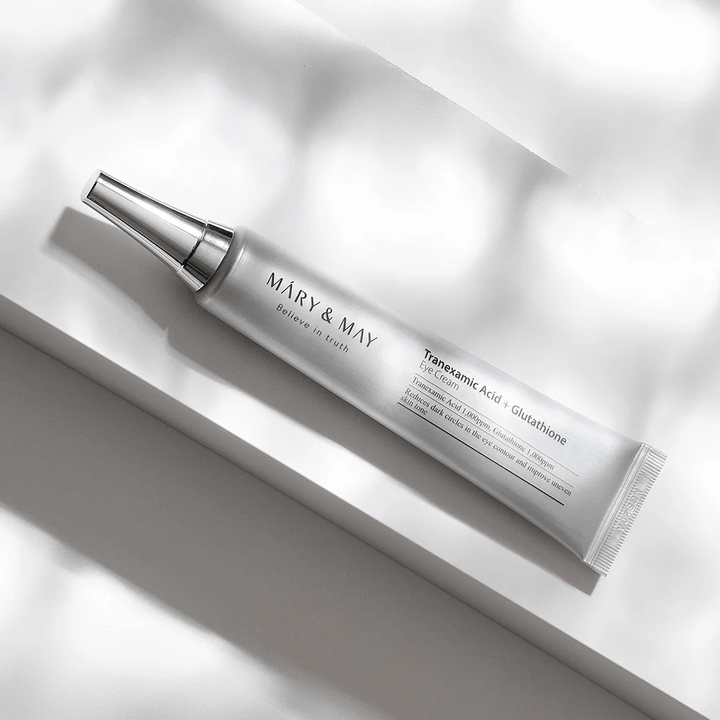 Nærbillede af Mary&May Tranexamic Acid + Glutathione Eye Cream med metalapplikator, udviklet til at lysne mørke rande og udjævne hudtonen omkring øjnene.