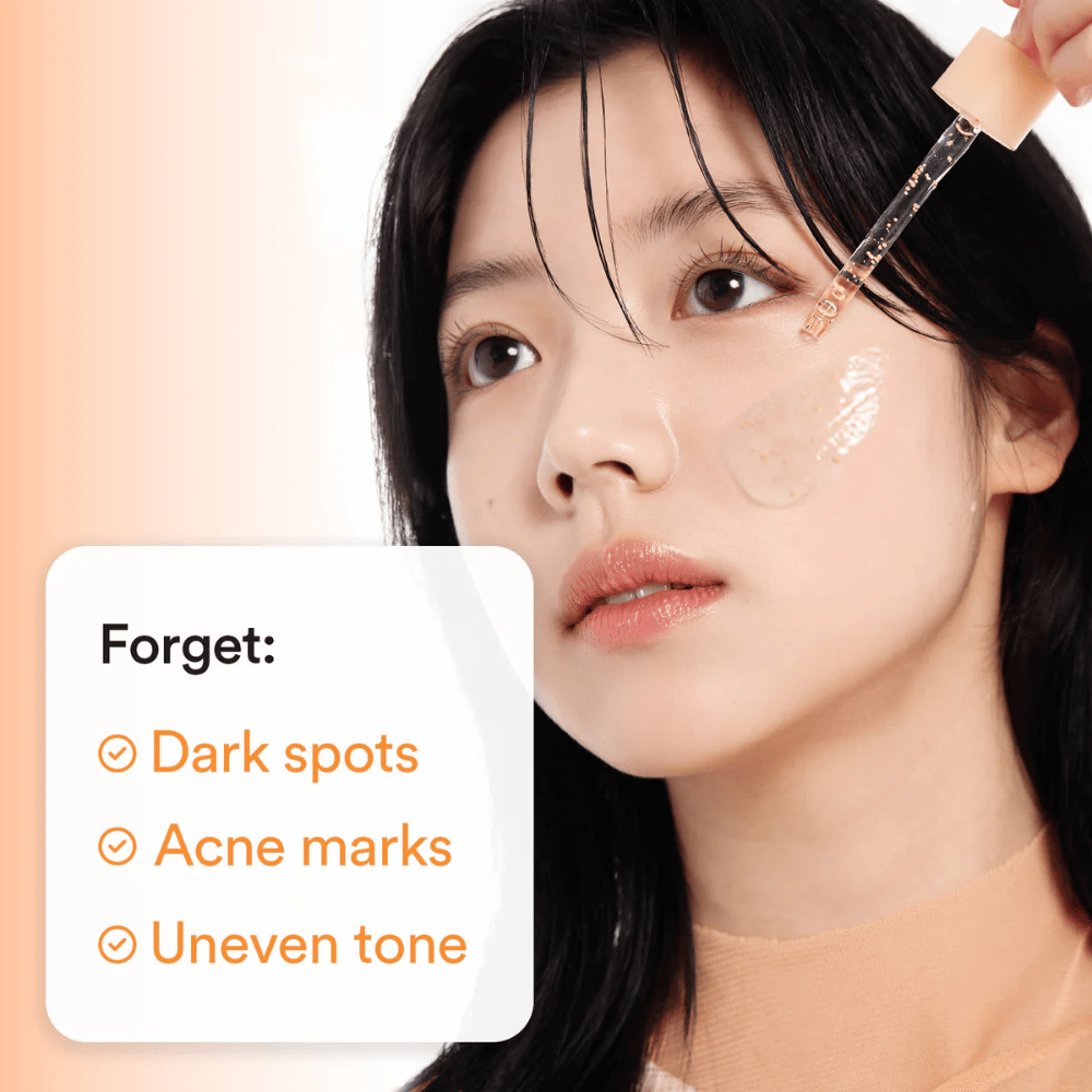 Kvinde anvender serum med pipette på kinden. Tekst på billedet oplister Fordele: "Forget: Dark spots, Acne marks, Uneven tone".