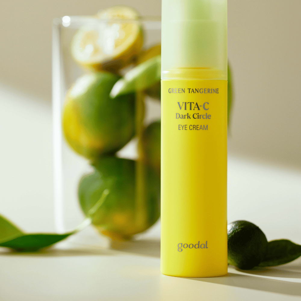 En flaske Goodal Green Tangerine Vita C Dark Circle Eye Cream 30ml på et bord ved siden af en lime.