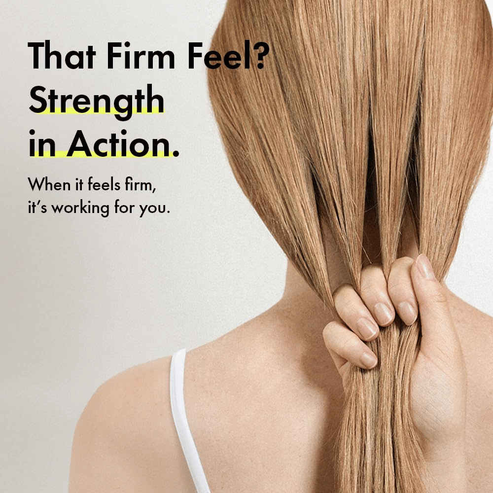 Person holder sit hår for at illustrere stærkere hårstrå og en fastere hårfornemmelse efter brug af Grabity g0.0 Hair Lifting Shampoo Strong.