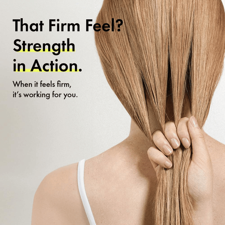 Person holder sit hår for at illustrere stærkere hårstrå og en fastere hårfornemmelse efter brug af Grabity g0.0 Hair Lifting Shampoo Strong.