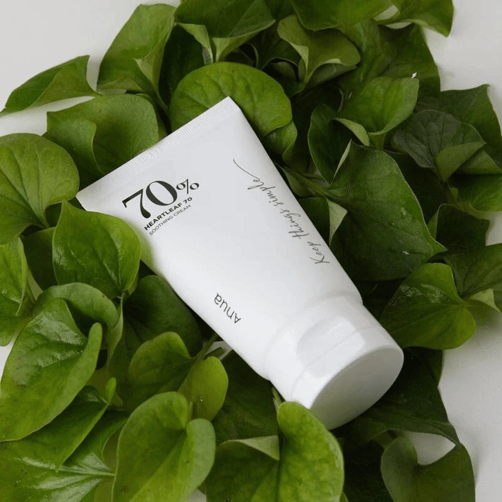 En tube af Heartleaf 70% Soothing Cream hviler på en seng af grønne blade.